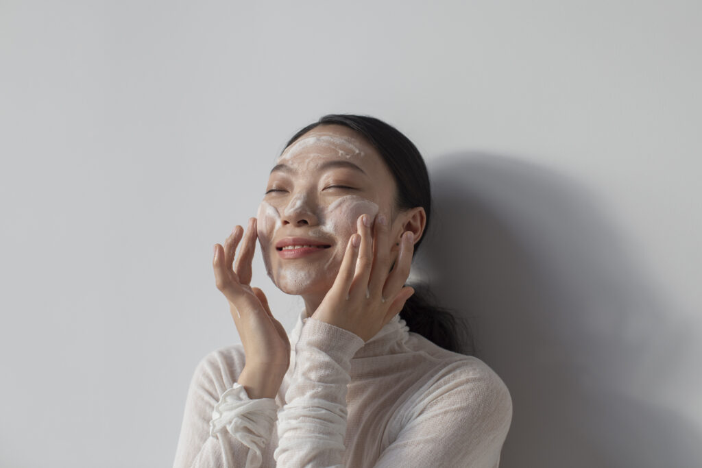Beautiful asian woman posing with facial cream