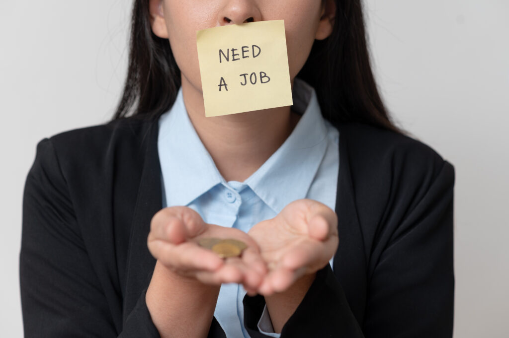 Women holding need a job text on paper note pad. jobless concept.