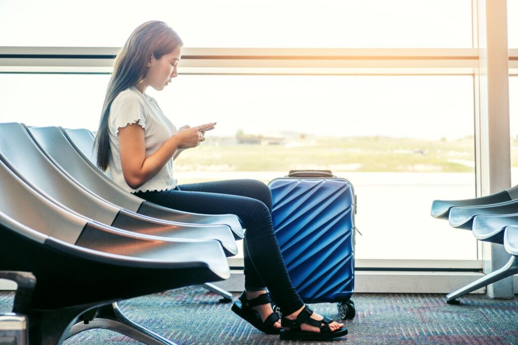 Side view woman using mobile phone airport terminal