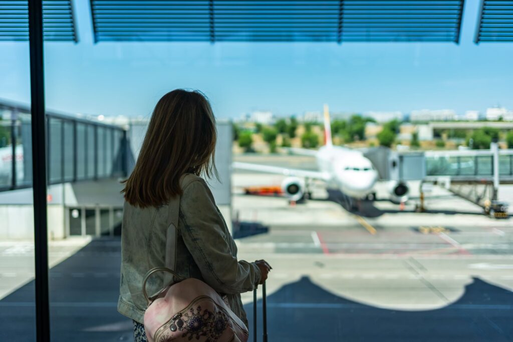 Woman with her back her waiting airport board plane parked terminal
